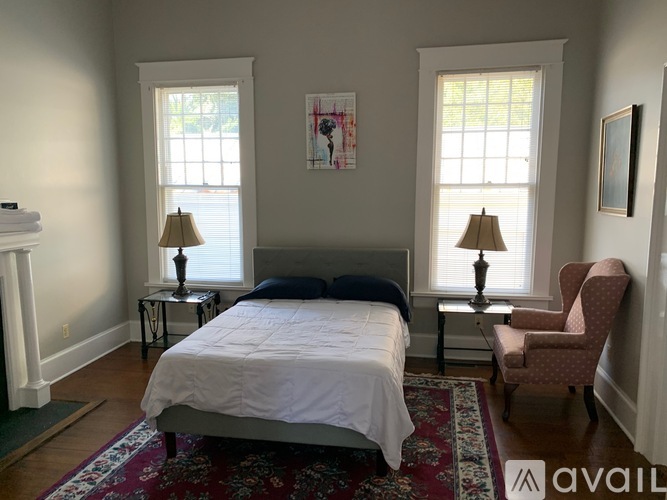 A bedroom with a large bed and a chair.
