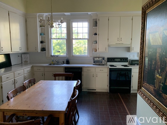 A kitchen with a table and chairs in front of it.