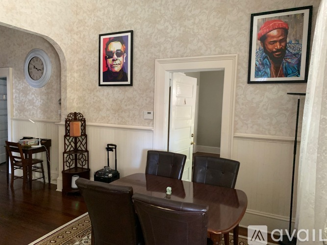 A living room with a brown leather couch and a wooden table.