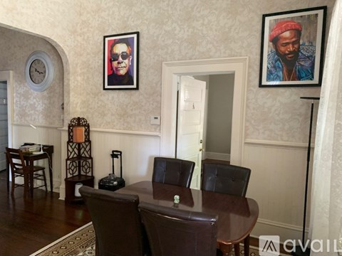 A living room with a brown leather couch and a wooden table.