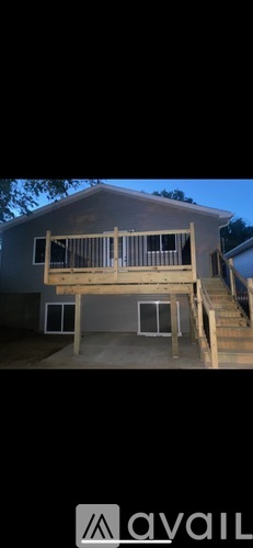 A house with a deck and stairs leading to the entrance.