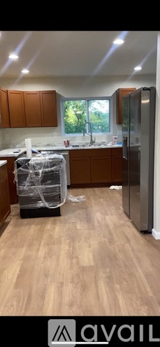 A kitchen with wooden cabinets and a refrigerator.