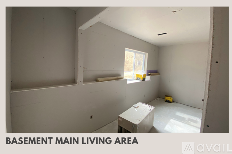 A basement main living area with a window and a workbench.