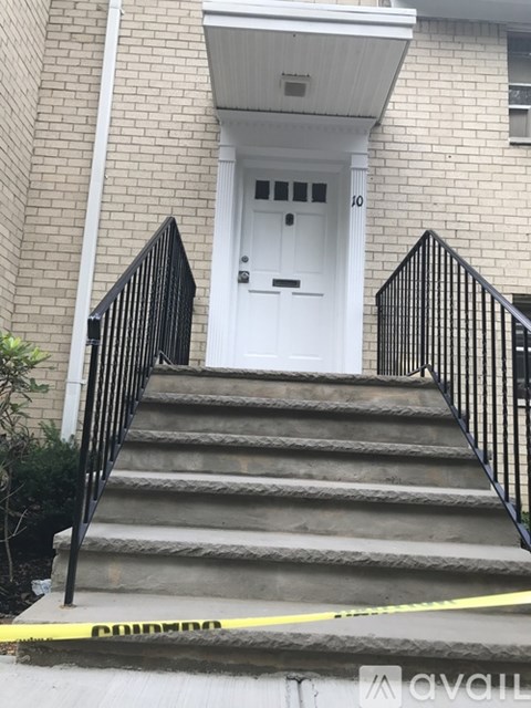 A white door is on the front of a brick building.