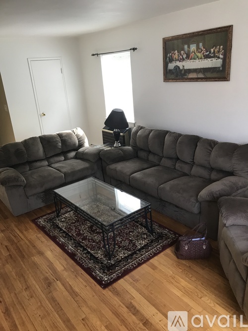 A living room with a grey sectional sofa and a glass coffee table.