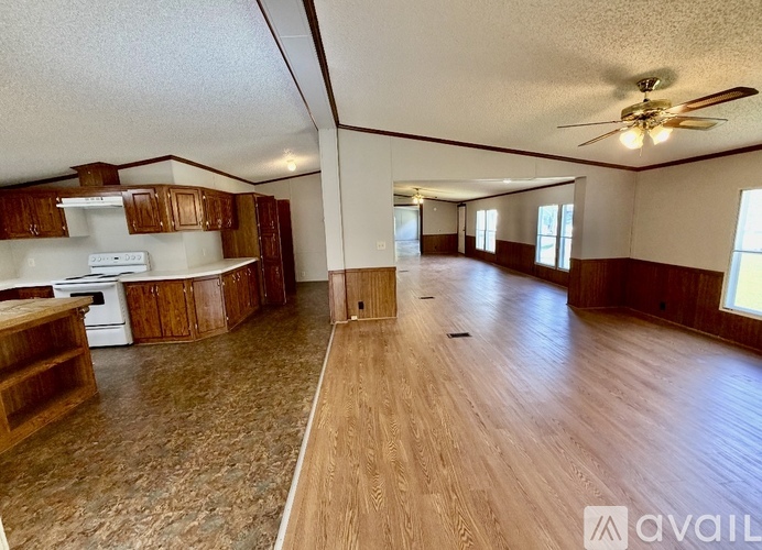 A spacious living room with wood flooring and a ceiling fan.