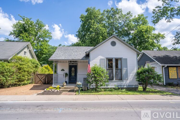 A house with a flag on the front porch is for sale.