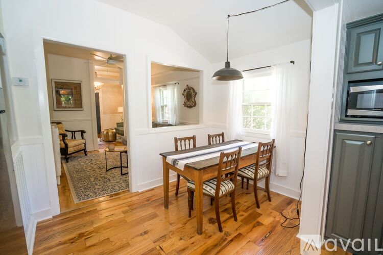 A dining room with a wooden table and chairs.