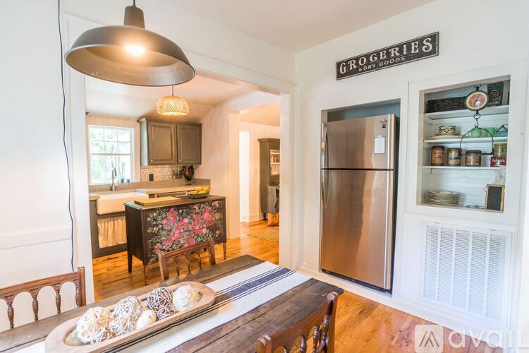 A kitchen with a refrigerator and a sign that says "Groceries" on the wall.