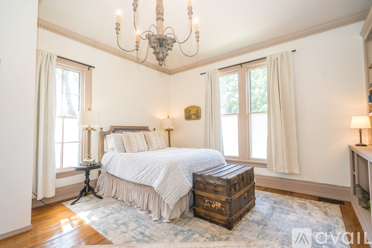 A bedroom with a large bed and a chandelier.