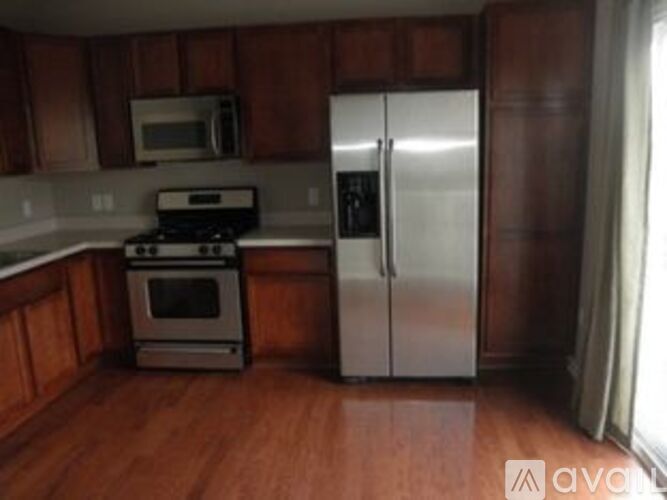 A kitchen with a stove, refrigerator, and microwave.