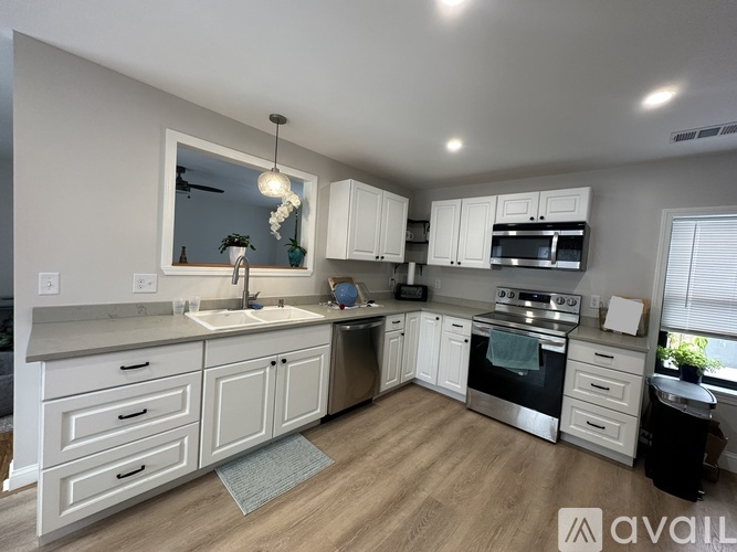 A modern kitchen with white cabinets and stainless steel appliances.