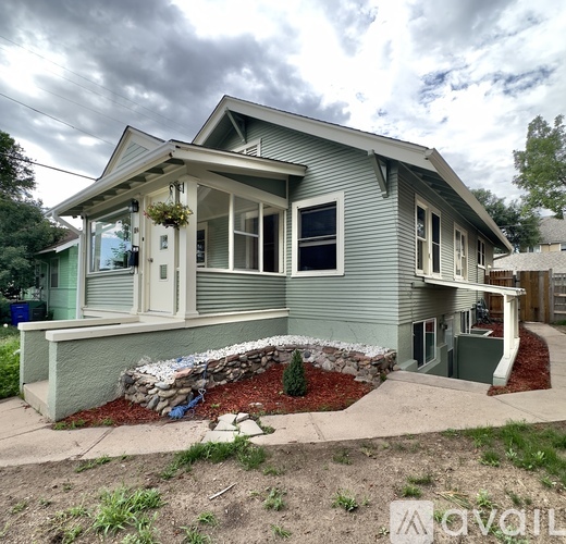 A house with a grey siding and a white door is for sale.