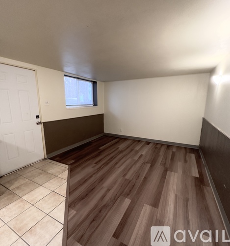 A room with wooden flooring and a white door.