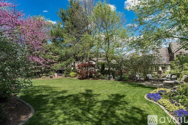 A beautifully landscaped garden with a variety of trees and flowers.