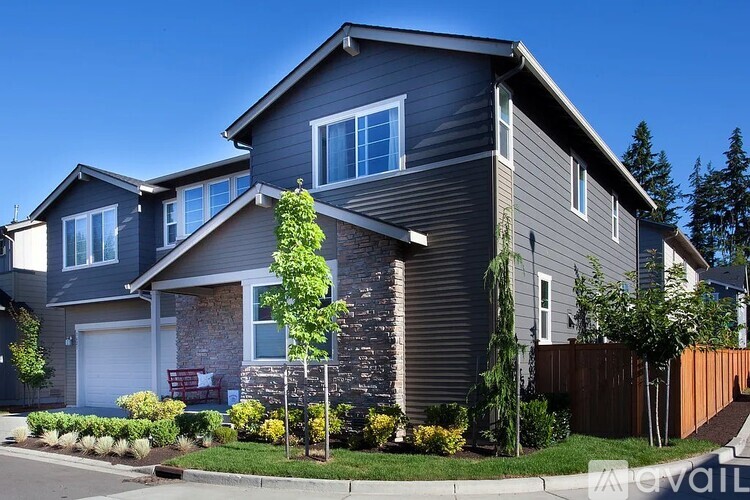 A modern house with a grey exterior and a white garage door.