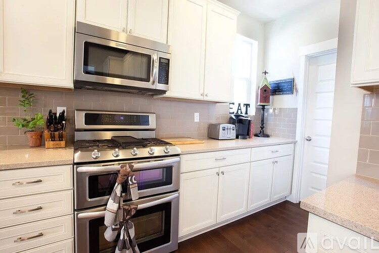 A kitchen with white cabinets and a stainless steel oven.