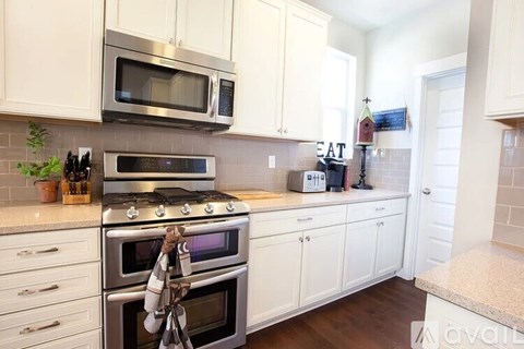 A kitchen with white cabinets and a stainless steel oven.