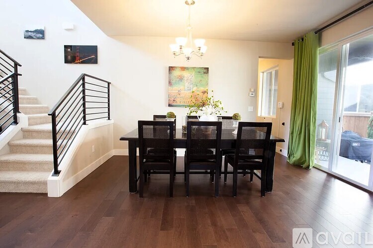 A dining room with a wooden table and chairs.