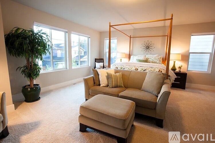 A bedroom with a four poster bed and a couch.