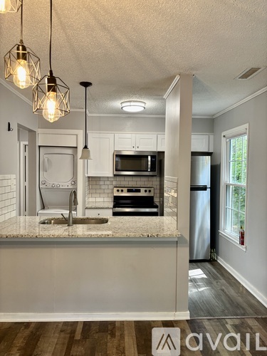 A kitchen with a white countertop and a microwave above it.