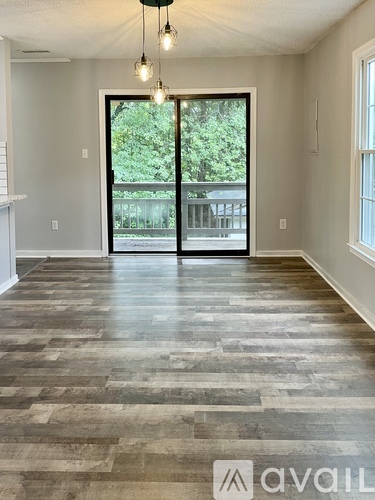 A room with a large door leading to a balcony.