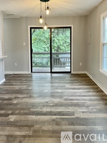 A room with a large door leading to a balcony.