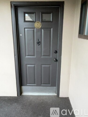 A black door with a gold plate on it.