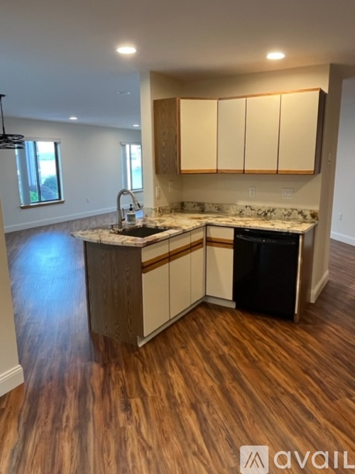 A kitchen with wooden floors and a marble countertop.