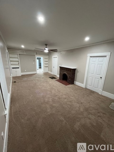 A living room with a fireplace and a carpeted floor.