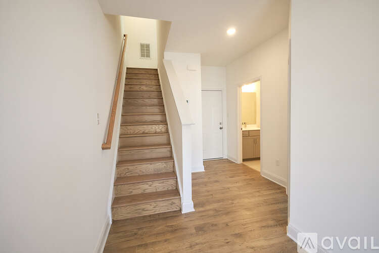 A hallway with a staircase leading to the second floor.