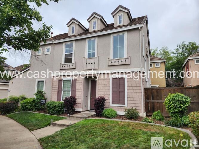 A house with a front yard and a driveway.