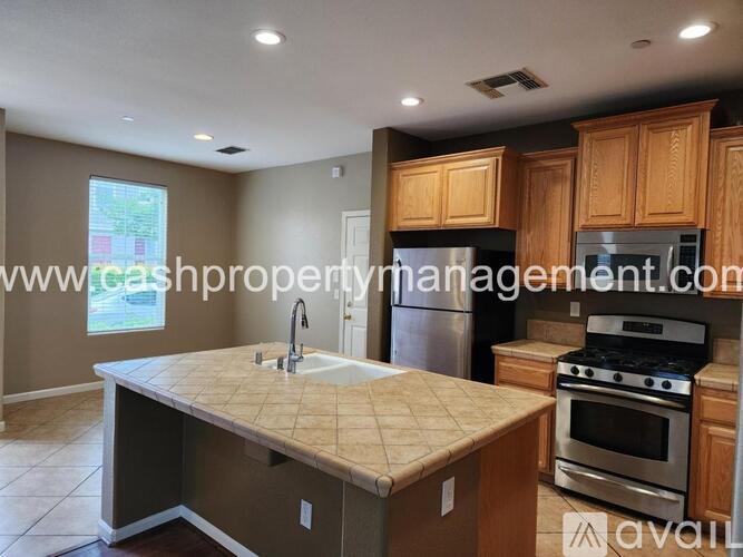 A kitchen with a large island in the middle and wooden cabinets.