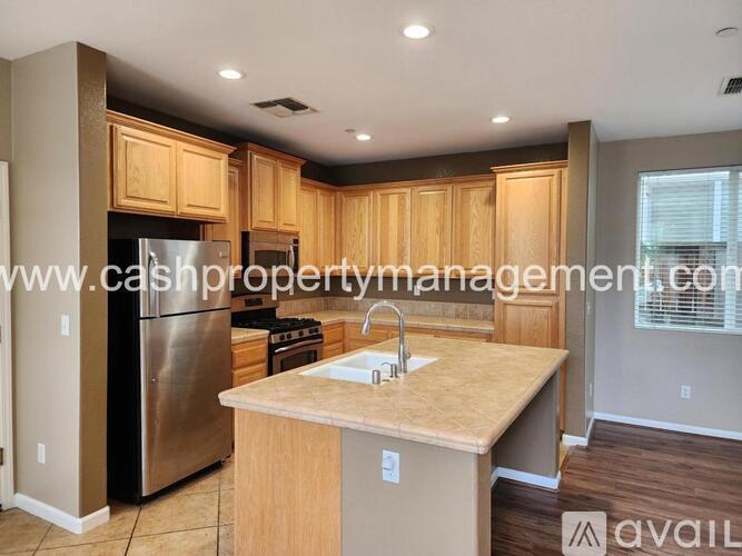 A kitchen with wooden cabinets and a stainless steel refrigerator.