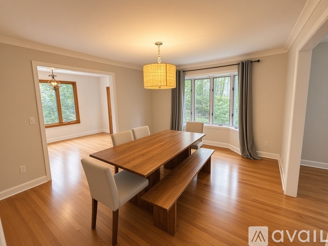A dining room with a wooden table and chairs.