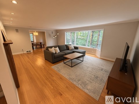A living room with a grey couch and a wooden floor.