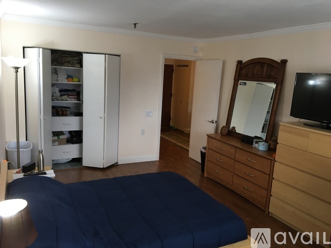 A bedroom with a bed, dresser, and mirror.