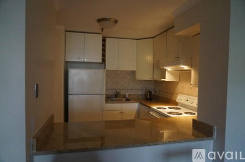 A kitchen with a stove top oven and a refrigerator.