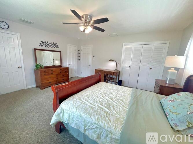 A bedroom with a bed, dresser, and mirror.