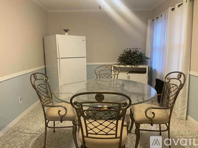 A dining room with a glass table and chairs.