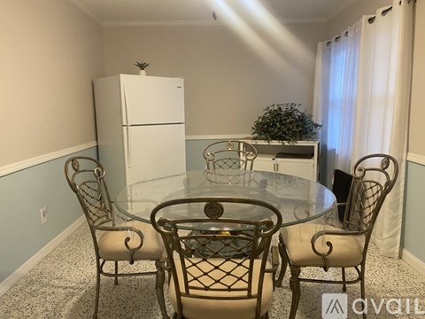 A dining room with a glass table and chairs.