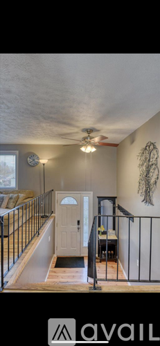 A living room with a ceiling fan and a painting on the wall.