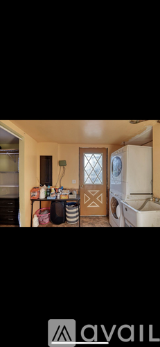 A room with a washing machine and a door.