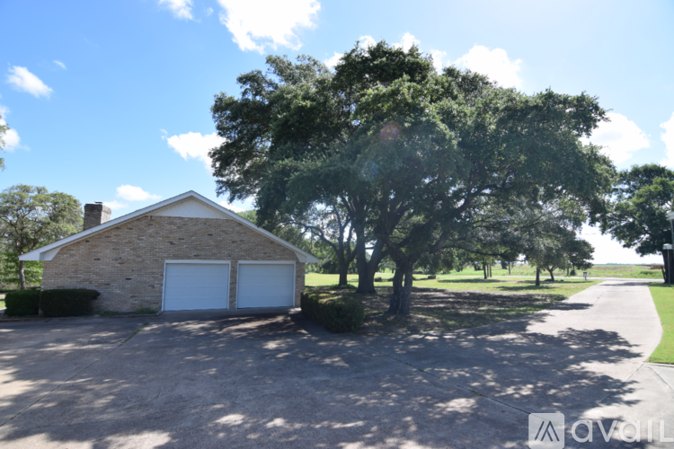 A house with a garage and a tree in front of it.