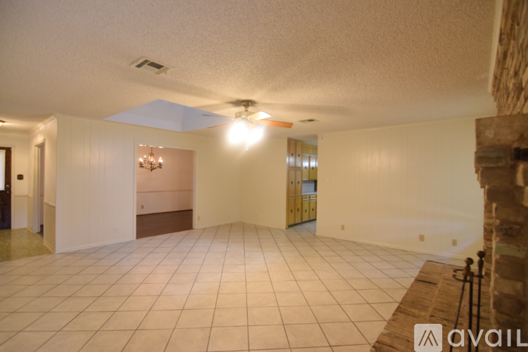 A spacious room with a tiled floor and a ceiling fan.