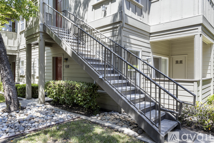 A staircase with a metal railing leads up to a door on a building.