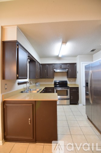 A kitchen with brown cabinets and a white counter top.