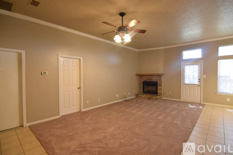 A living room with a fireplace and a ceiling fan.