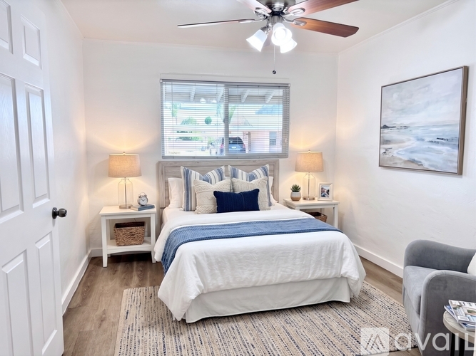A bedroom with a large bed and a ceiling fan.
