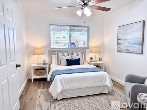 A bedroom with a large bed and a ceiling fan.